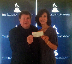 Bill Lloyd presenting a MusiCares donation check
